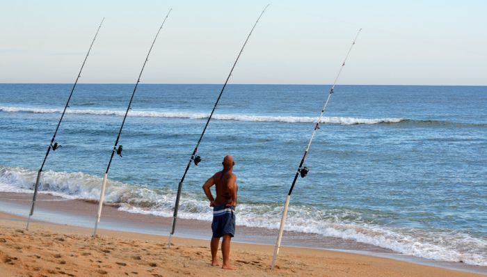 Fisherman standing waiting in front of beach