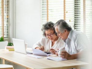 Stress Asian Senior Couple using calculator and calculate family budget, Debts, monthly expenses in home during Financial economic crisis. Elderly man, woman looking at bill, passbook, receipt, laptop